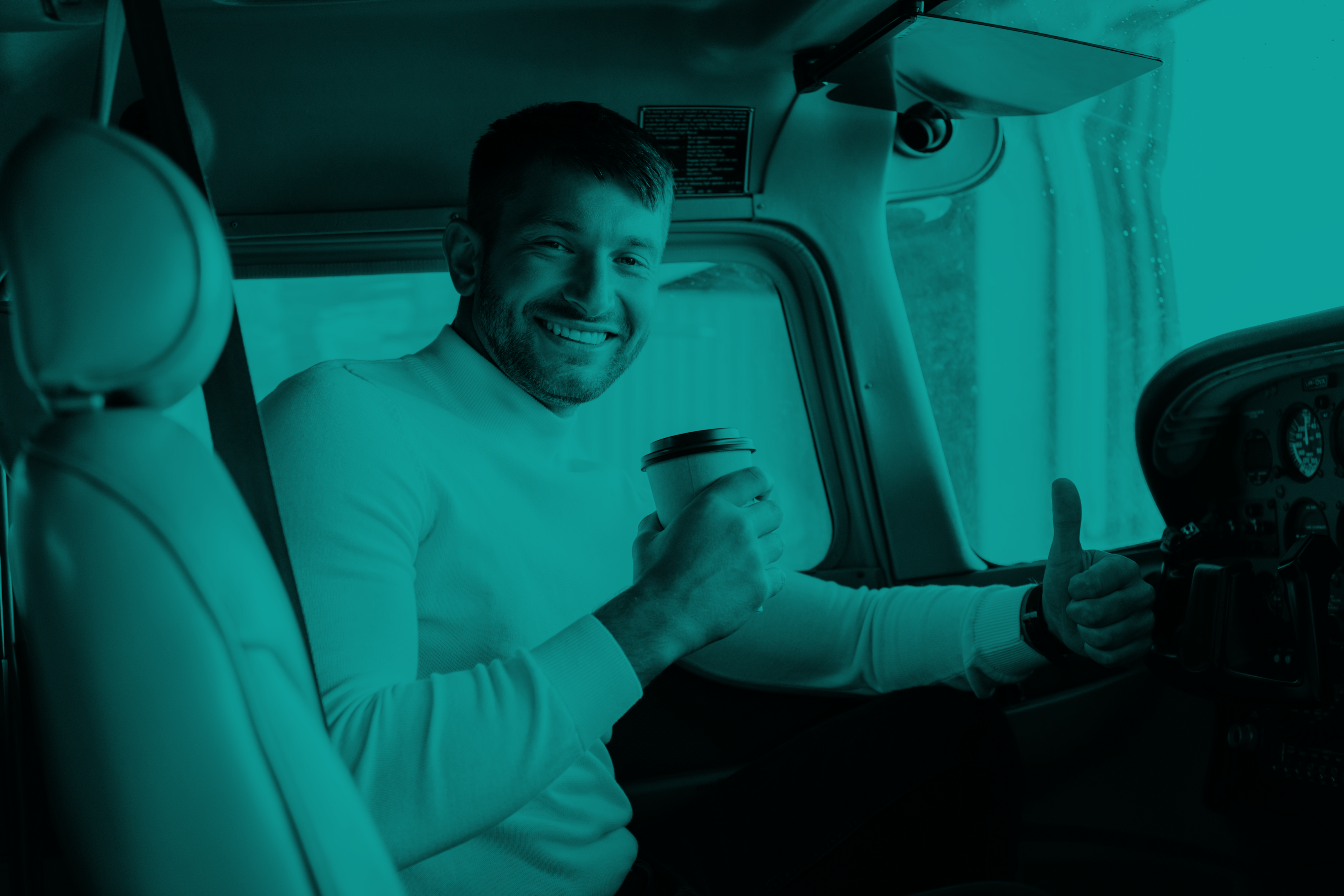 Smiling pilot sitting in the left seat with a coffee and giving a thumbs up