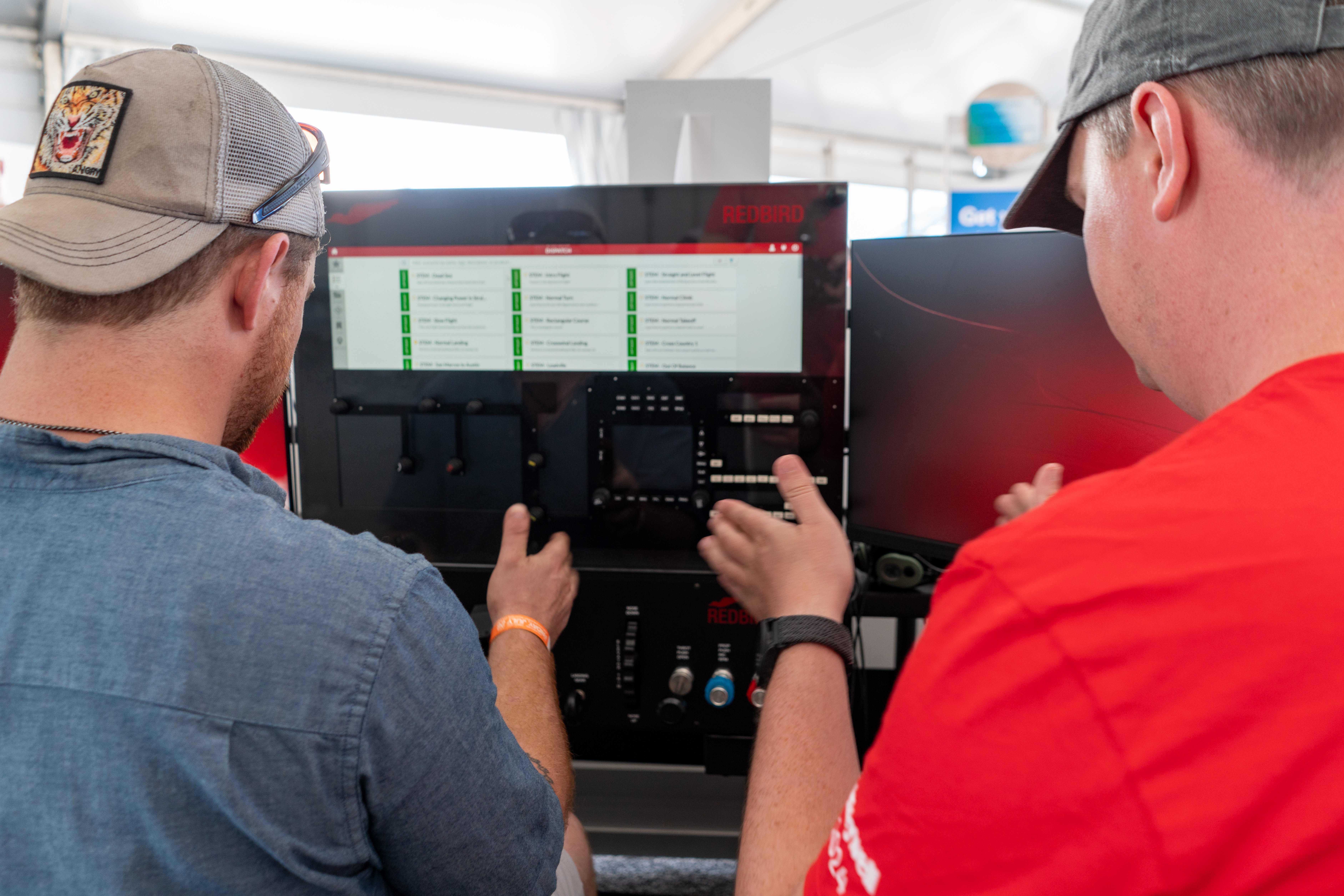 Pilots choosing a scenario to fly on a Redbird TD2