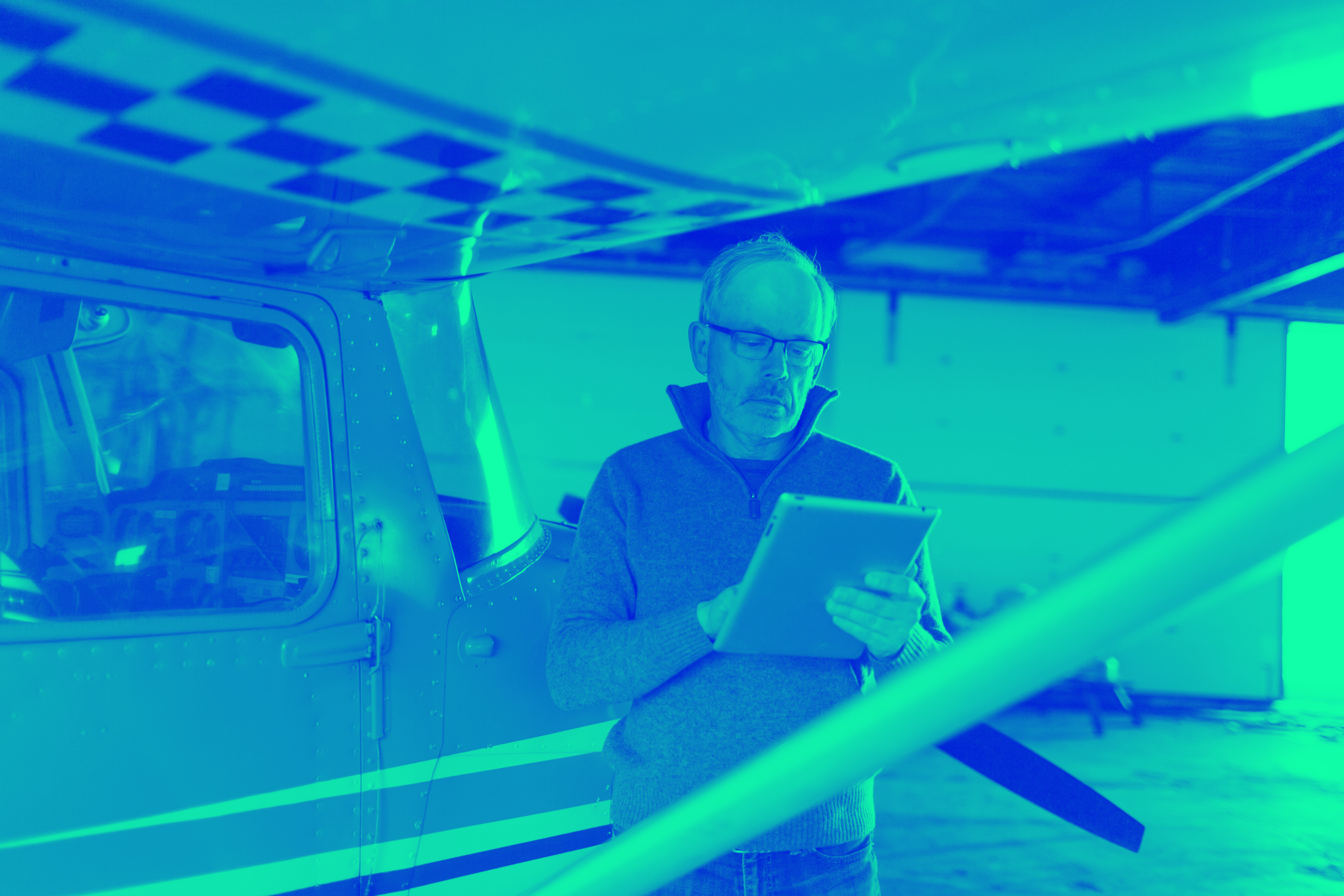 Pilot using an iPad next to his airplane